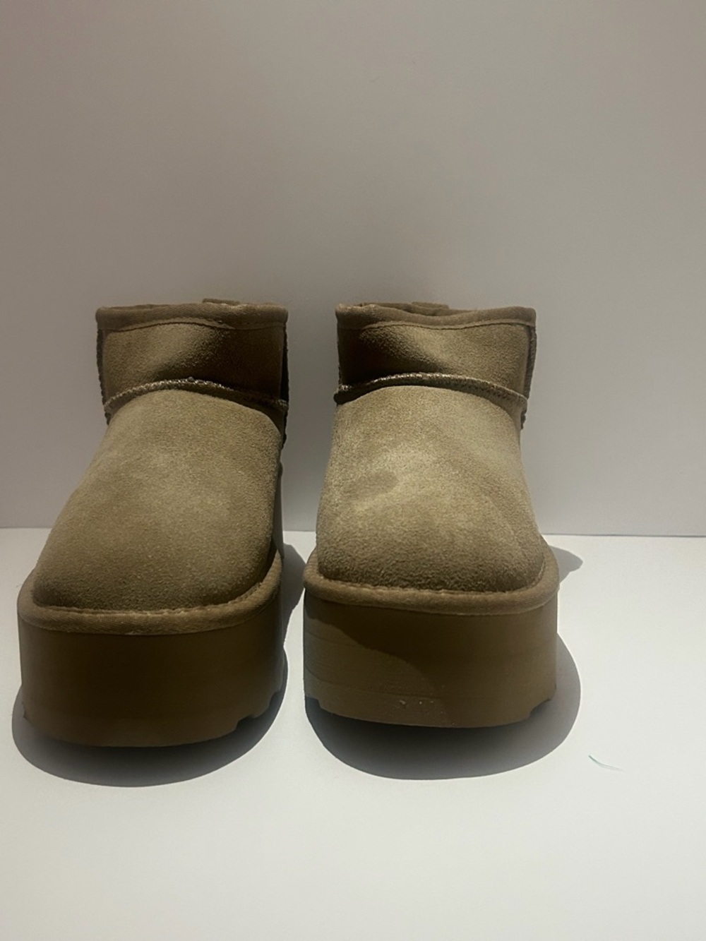 Trendy platform mini boots in a neutral tan color.